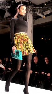Natalia; Citron barbed wire knife pleat skirt with black crop ponti turtleneck. peacock envelope clutch and black, satin round toe pumps.